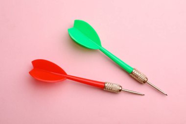 Pembe arka plan üzerinde plastik dart okları, düz yatıyordu