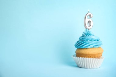 Mavi arka plan üzerinde altı numaralı mum ile Doğum günü cupcake, metin için alan