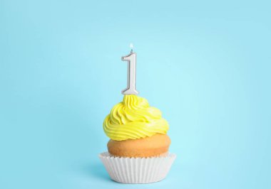 Mavi arka plan üzerinde bir numaralı mum ile Doğum günü cupcake