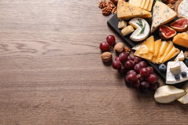 Ahşap masada servis edilen farklı lezzetli peynir çeşitleri, metin için alan