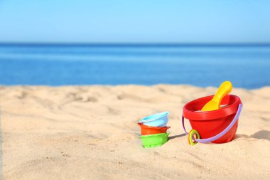 Deniz yakınında kum üzerinde plastik plaj oyuncakları ayarlayın. Metin alanı