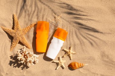 Kumlu plajda güneş kremi şişeleri ile Düz yatıyordu kompozisyon