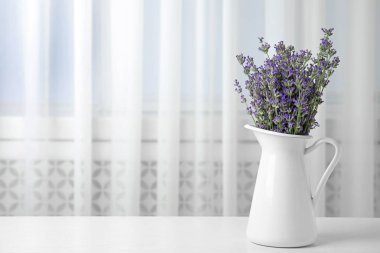 Beyaz masa kapalı sürahi güzel ihale lavanta çiçekleri, metin için alan