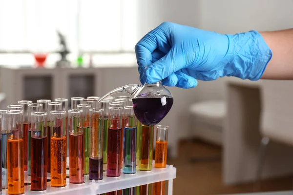 Wissenschaftler gießt Flüssigkeit aus Retortenflasche in Reagenzglas im Labor, Nahaufnahme. Lösungschemie — Stockfoto