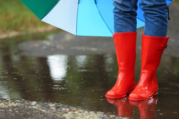 Kobieta z parasolem i gumowymi butami w Puddle, zbliżenie. Deszczowa pogoda — Zdjęcie stockowe