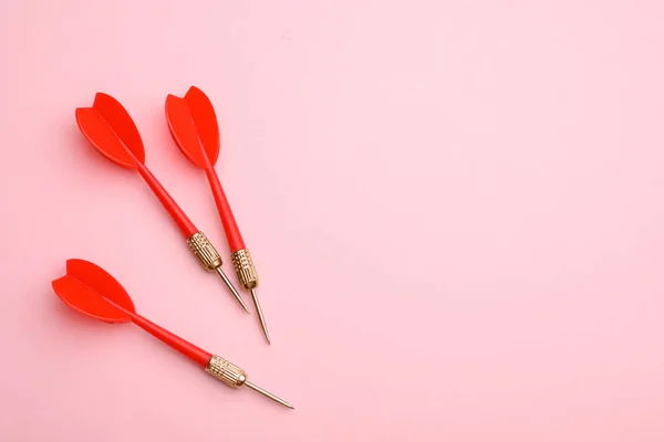 Flechas de dardo rojo sobre fondo rosa, plano con espacio para el texto —  Fotos de Stock