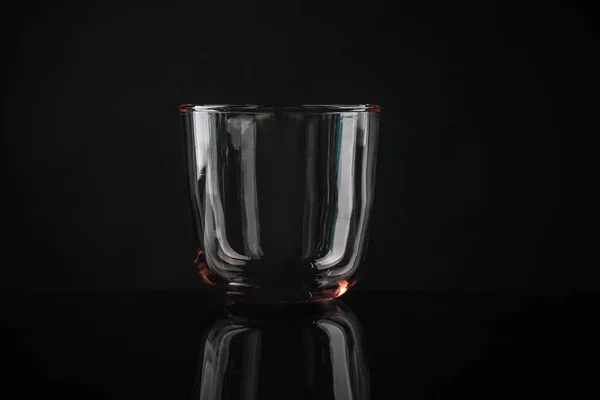 Vidro de uísque colorido vazio elegante no fundo preto — Fotografia de Stock