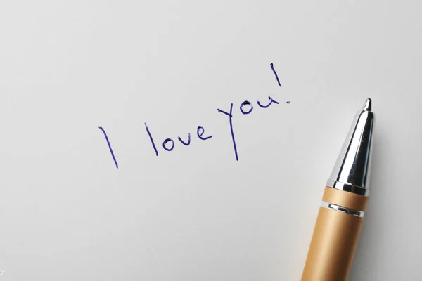 Palavras escritas Eu te amo e caneta em papel branco, vista superior — Fotografia de Stock