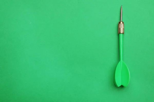 Plastikowa strzałka dart na zielonym tle, widok z góry z miejsca na tekst — Zdjęcie stockowe