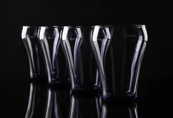 Ensemble de verres colorés vides sur fond noir — Photo