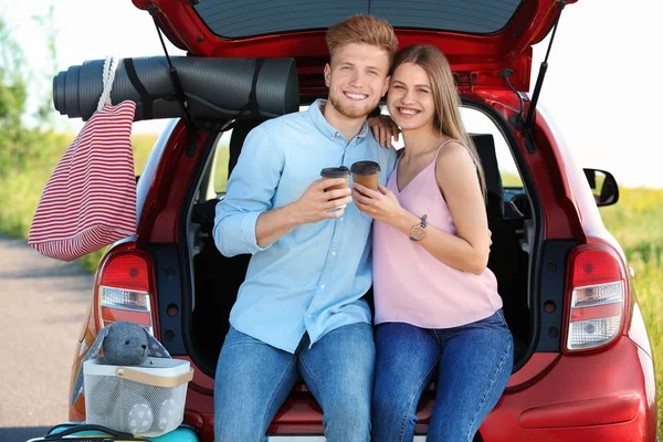 Jeune couple avec bagages près du coffre de la voiture à l'extérieur — Photo