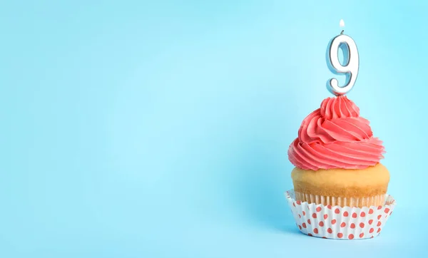 Cupcake d'anniversaire avec numéro neuf bougie sur fond bleu, espace pour le texte — Photo