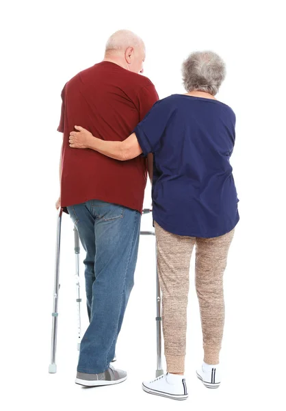 老年妇女帮助她的丈夫与白色背景行走框架 — 图库照片