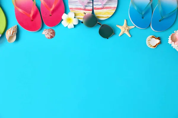 Platte lay compositie met verschillende flip-flops op blauwe achtergrond, ruimte voor tekst. Zomer strand accessoires — Stockfoto