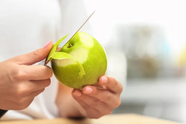 Femme pelant pomme verte fraîche à l'intérieur, gros plan. Espace pour le texte — Photo