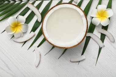 Beyaz ahşap arka plan üzerinde hindistan cevizi yarısı ile Kompozisyon