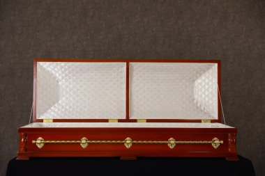 Açık ahşap cenaze tabut gri duvarda standında