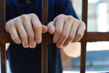 Dışarıda hapiste, yakın çekimde gözaltına alınan adam. Ceza hukuku