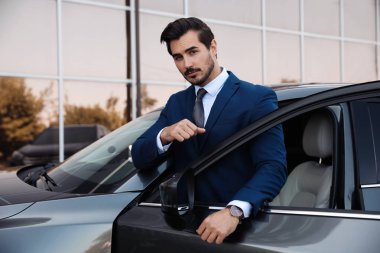 Çekici genç adam yakın lüks araba açık havada