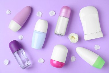 Mor arka plan üzerinde farklı kadın deodorantlar ile düz yatıyordu kompozisyon