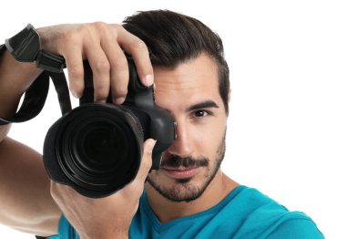 Genç profesyonel fotoğrafçı beyaz arka planda fotoğraf çekiyor