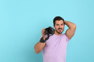 Açık mavi arka plan profesyonel kamera ile genç fotoğrafçı. Metin için alan