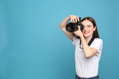 Açık mavi arka planda fotoğraf çeken profesyonel fotoğrafçı. Metin için alan