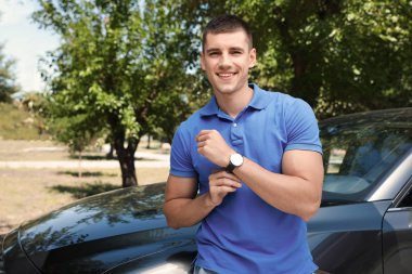 Çekici genç adam yakın lüks araba açık havada