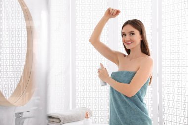 Güzel genç kadın banyoda duş sonra deodorant uygulamak