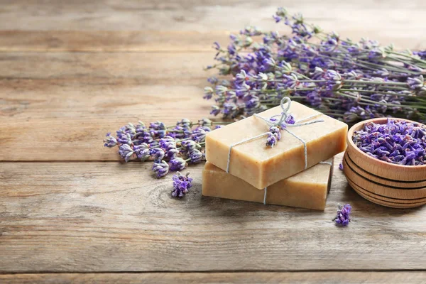 Saponette fatte a mano con fiori di lavanda su tavolo di legno marrone. Spazio per testo — Foto Stock