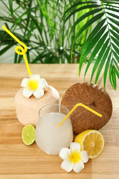 Složení se sklenicí kokosové vody na dřevěném stole proti rozostřené pozadí — Stock fotografie