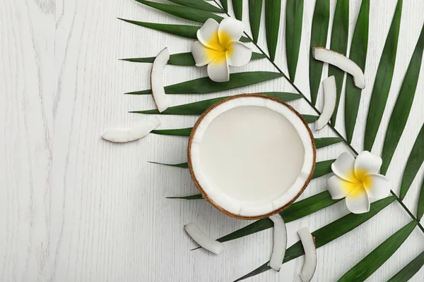 Composición plana con la mitad de coco sobre fondo de madera blanca. Espacio para texto — Foto de Stock