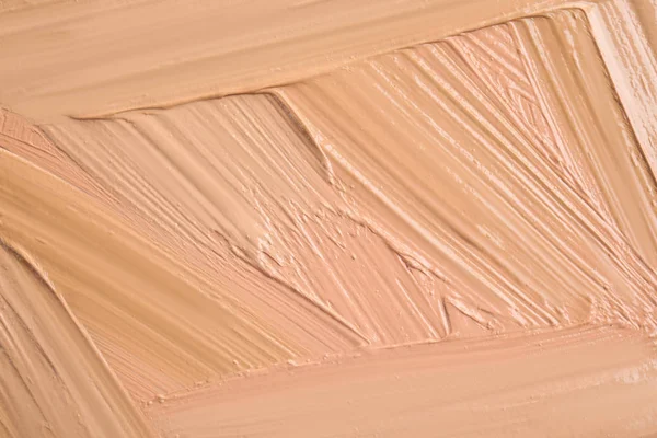 Samples of different foundation shades as background, top view