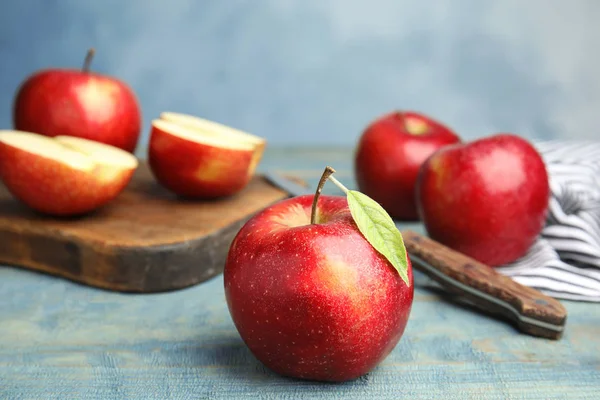 Pommes rouges juteuses mûres sur table en bois sur fond bleu. Espace pour le texte — Photo