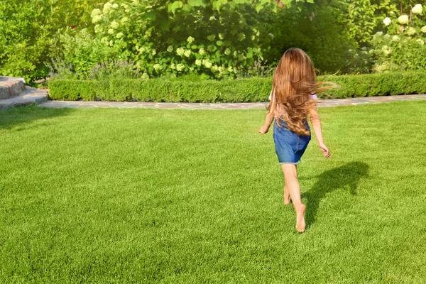 Χαριτωμένο μικρό κορίτσι τρέχει στο πράσινο πάρκο τη θερινή ημέρα — Φωτογραφία Αρχείου