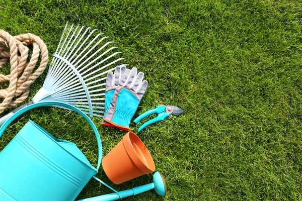Set of gardening tools on green grass, flat lay — Stock Photo, Image