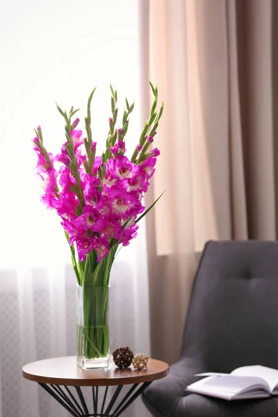 Jarrón con hermosas flores de gladiolo rosa en la mesa de madera en la habitación, espacio para el texto —  Fotos de Stock