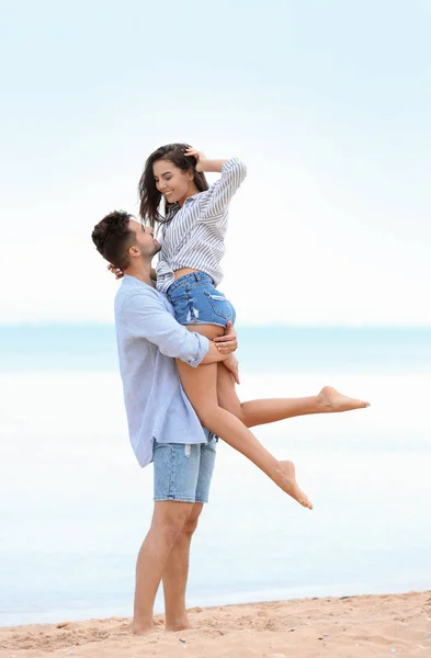 Happy Young par umgås tillsammans på stranden nära havet — Stockfoto