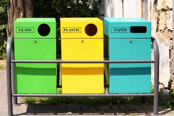 Waste sorting bins on city street. Recycling concept