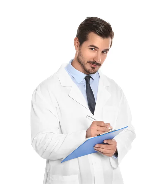 Jovem médico do sexo masculino escrevendo na área de transferência contra fundo branco. Serviço médico — Fotografia de Stock