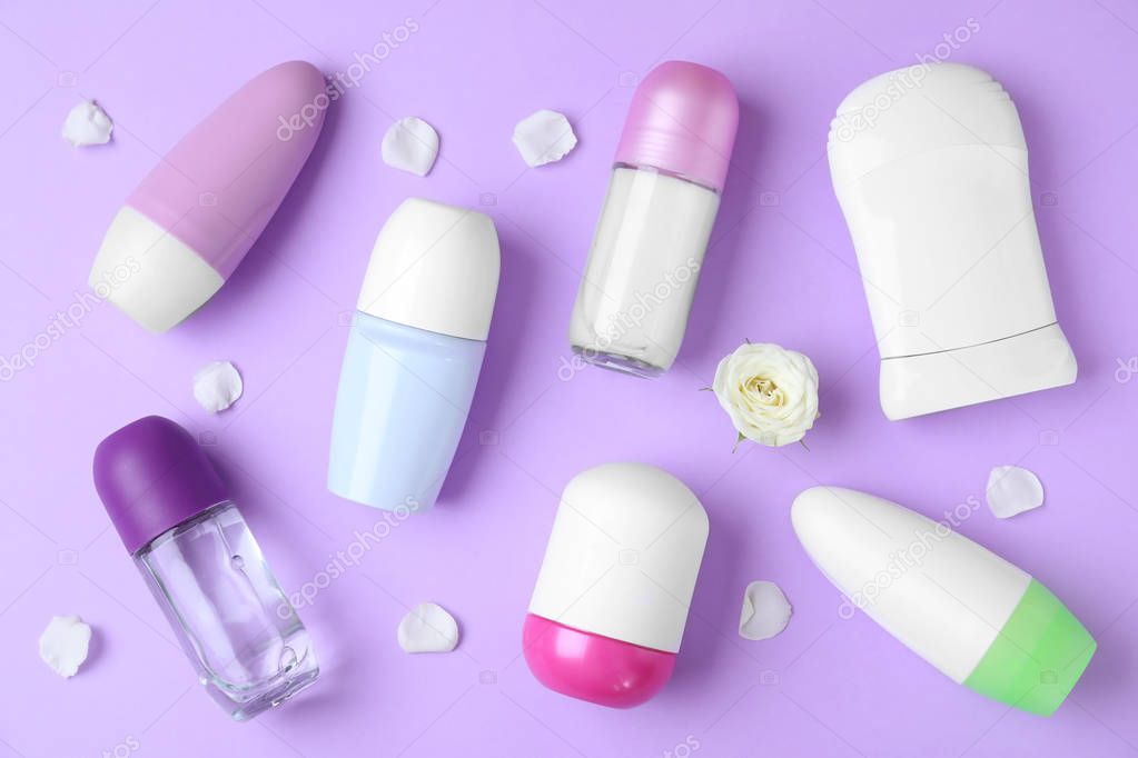 Flat lay composition with different female deodorants on purple background