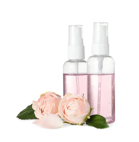 Flaschen ätherisches Öl und Rosen auf weißem Hintergrund — Stockfoto