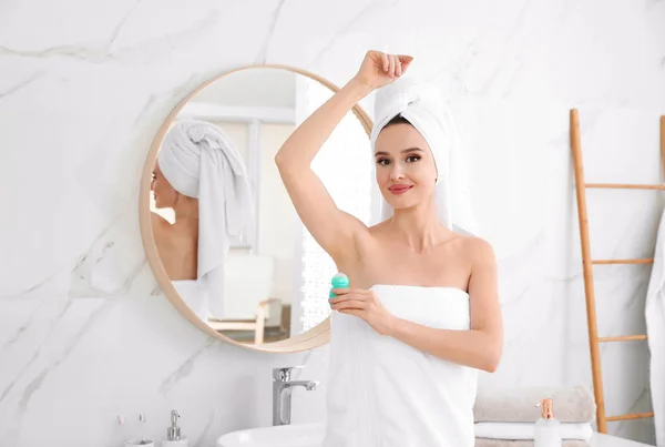 Красива молода жінка застосовує дезодорант після душу у ванній — стокове фото
