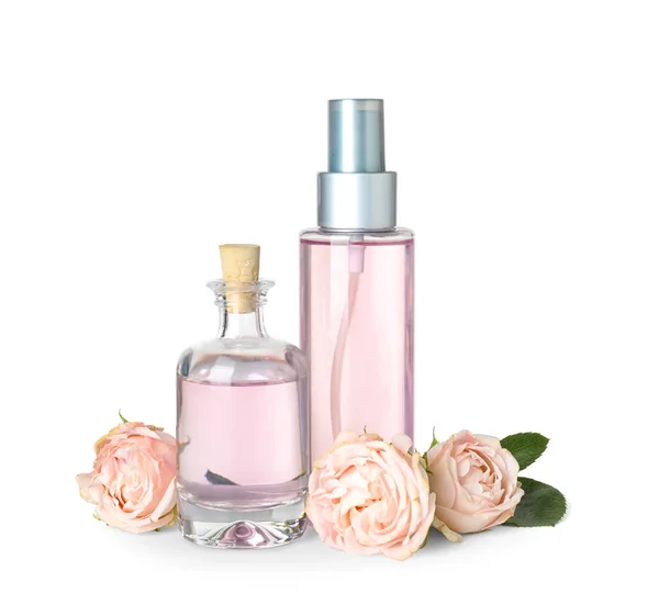 Flaskor av eterisk olja och rosor på vit bakgrund — Stockfoto