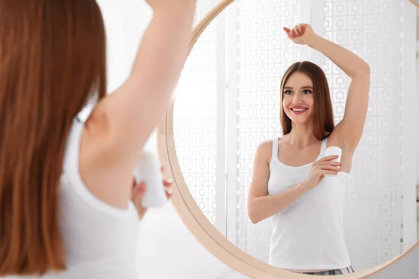 Vacker ung kvinna ansöker deodorant i badrum — Stockfoto