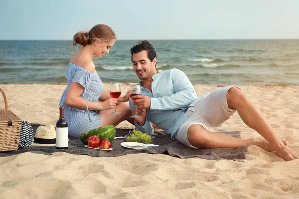 海のビーチでピクニックを持つ美しい若いカップル — ストック写真