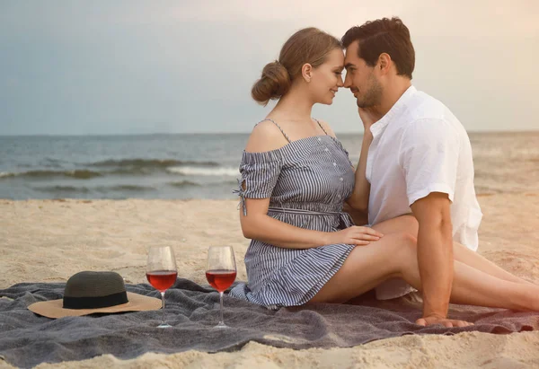 海のビーチでピクニックを持つ幸せな若いカップル — ストック写真