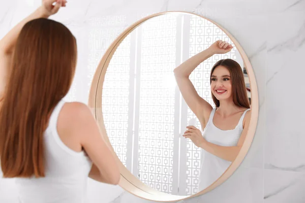 Belle jeune femme appliquant déodorant dans la salle de bain — Photo