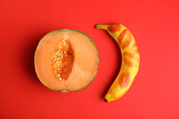 Flat lay composition with fresh banana and melon on red background. Sex concept