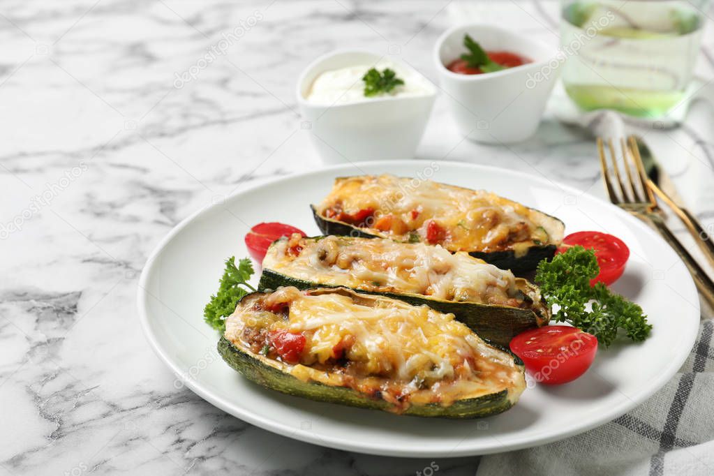 Baked stuffed zucchinis served on white marble table